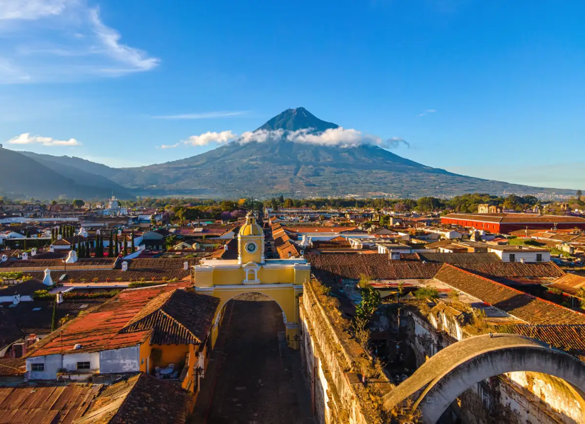 Vista panorámica de Antigua Guatemala con un volcán de fondo
