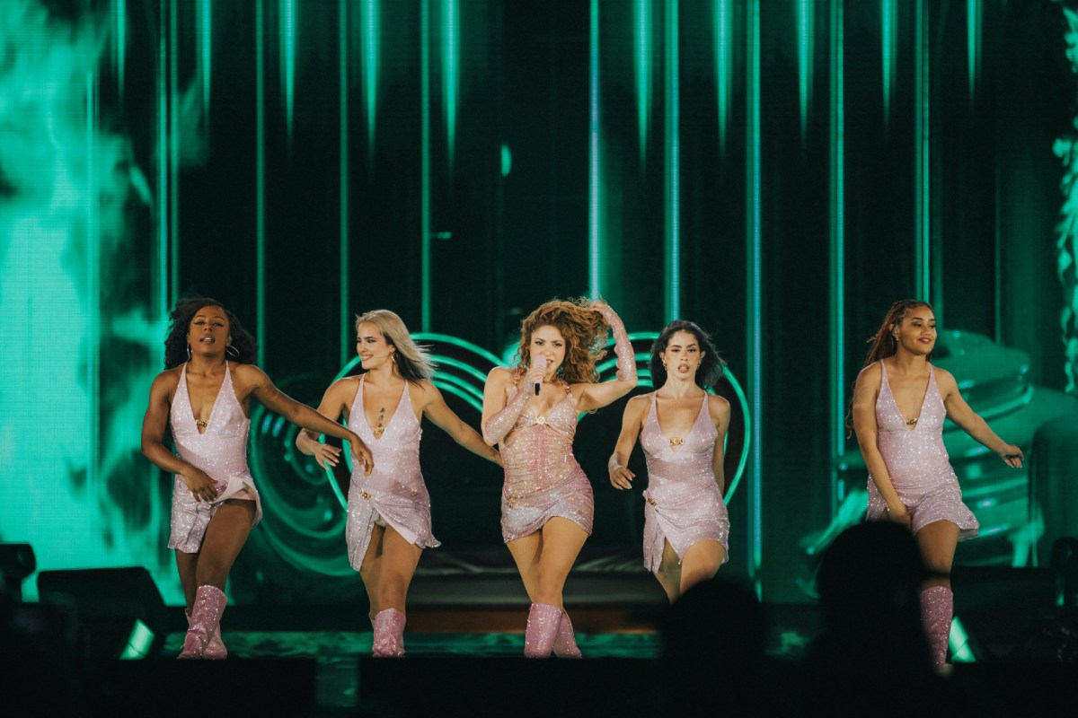 La cantante Shakira bailando en el escenario junto a 4 mujeres.